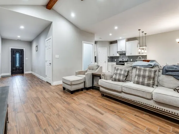 a living room with furniture and a wooden floor