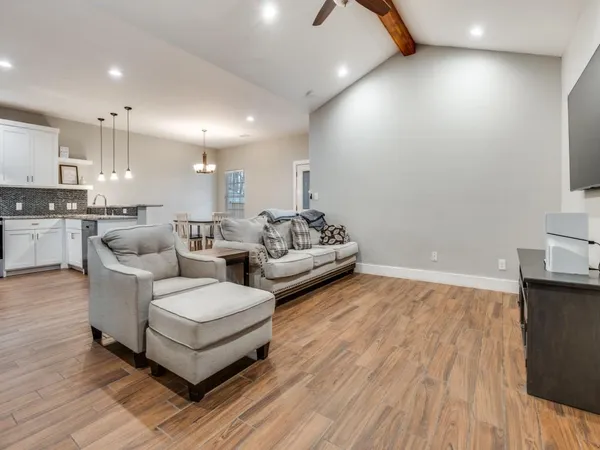 an open kitchen with wooden floor and stainless steel appliances