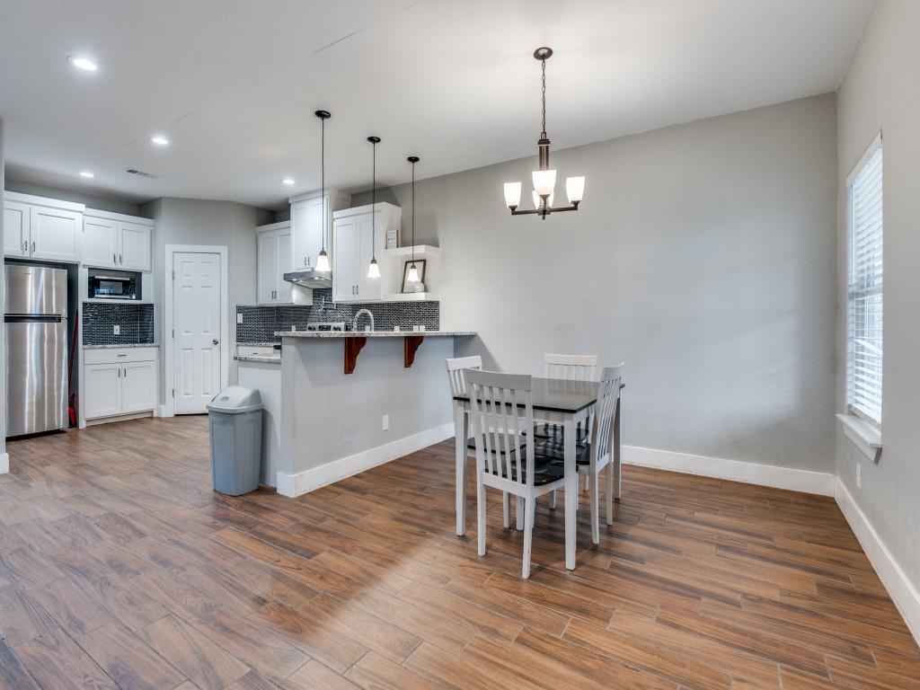 908 East Decatur Street Ennis, TX 75119 - Photo 6 of 22 an open kitchen with wooden floor and stainless steel appliances