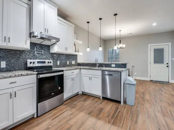 a kitchen with stainless steel appliances granite countertop a stove sink and cabinets