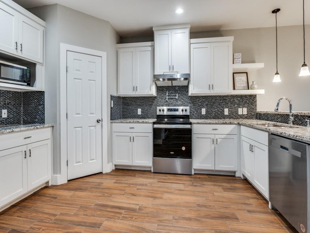 908 East Decatur Street Ennis, TX 75119 - Photo 10 of 22 a kitchen with stainless steel appliances granite countertop a stove sink and cabinets