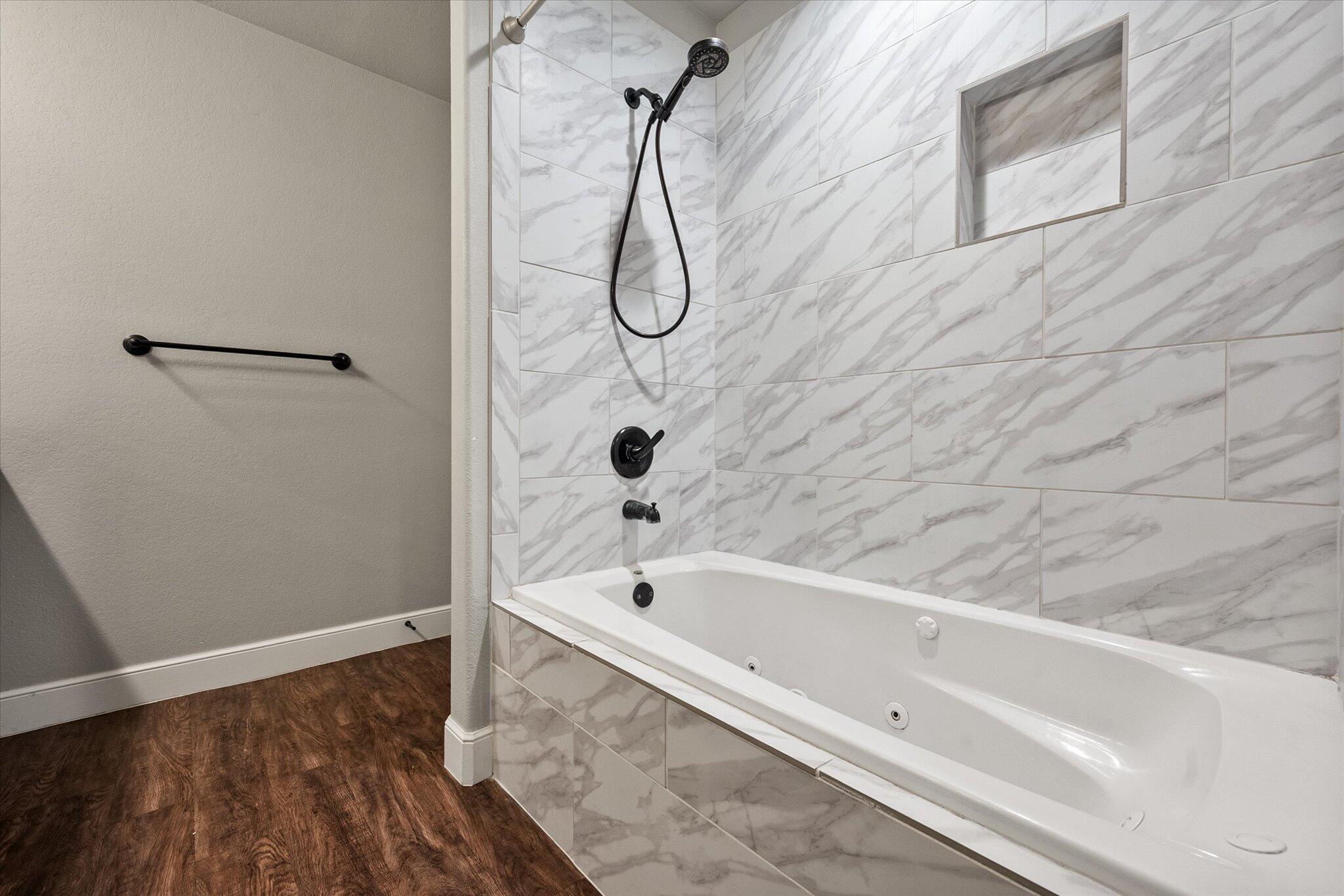 4916 Itasca Street Lubbock, TX 79416 - Photo 18 of 27 a bathroom with a bath tub with a shower