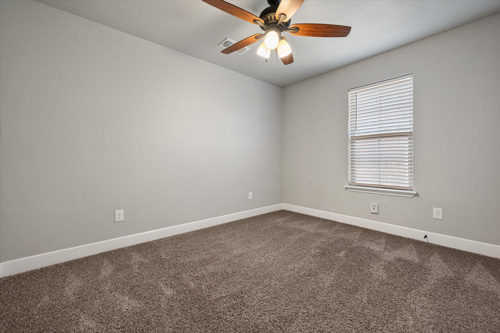 4916 Itasca Street Lubbock, TX 79416 - Photo 22 of 27 an empty room with a window and a fan