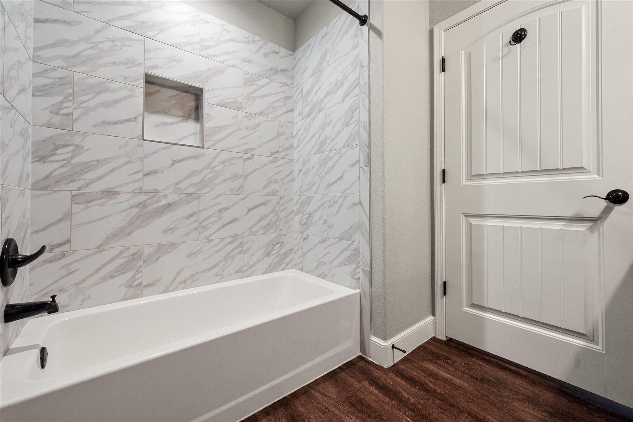 4916 Itasca Street Lubbock, TX 79416 - Photo 23 of 27 a bathroom with a bathtub and a shower