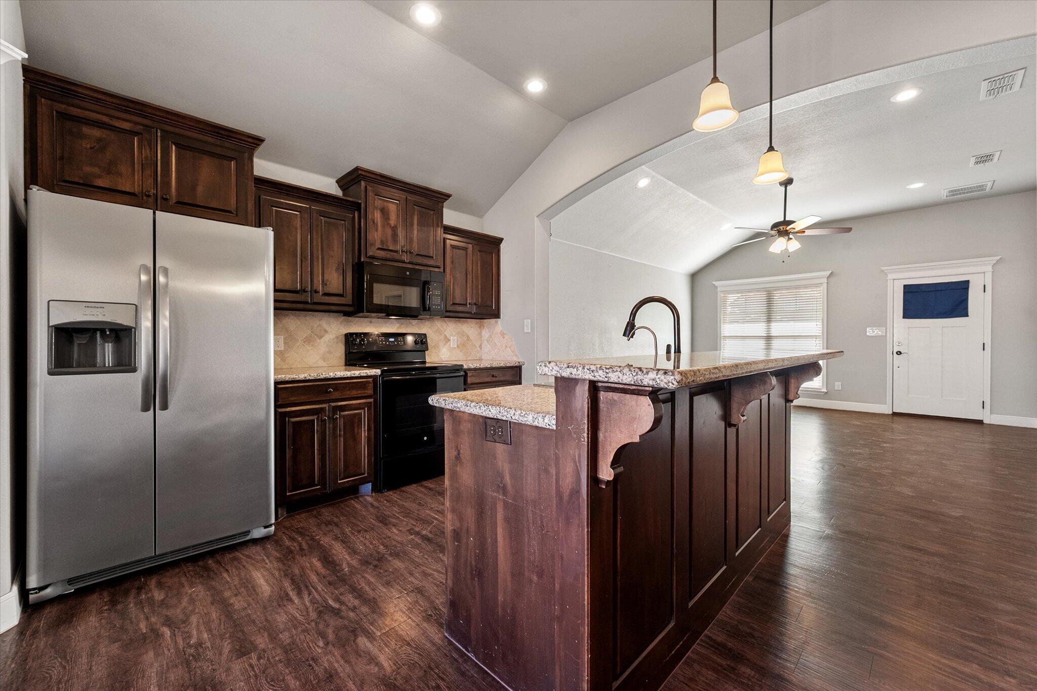 4916 Itasca Street Lubbock, TX 79416 - Photo 8 of 27 a kitchen with granite countertop a refrigerator a stove top oven a sink and dishwasher