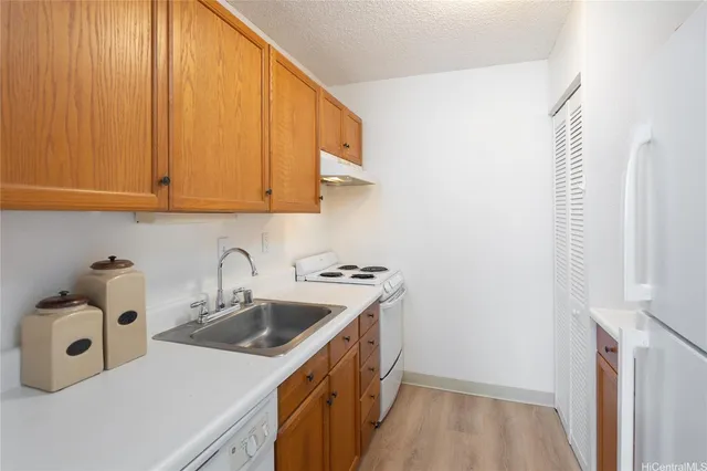 a kitchen with a sink a stove and a refrigerator