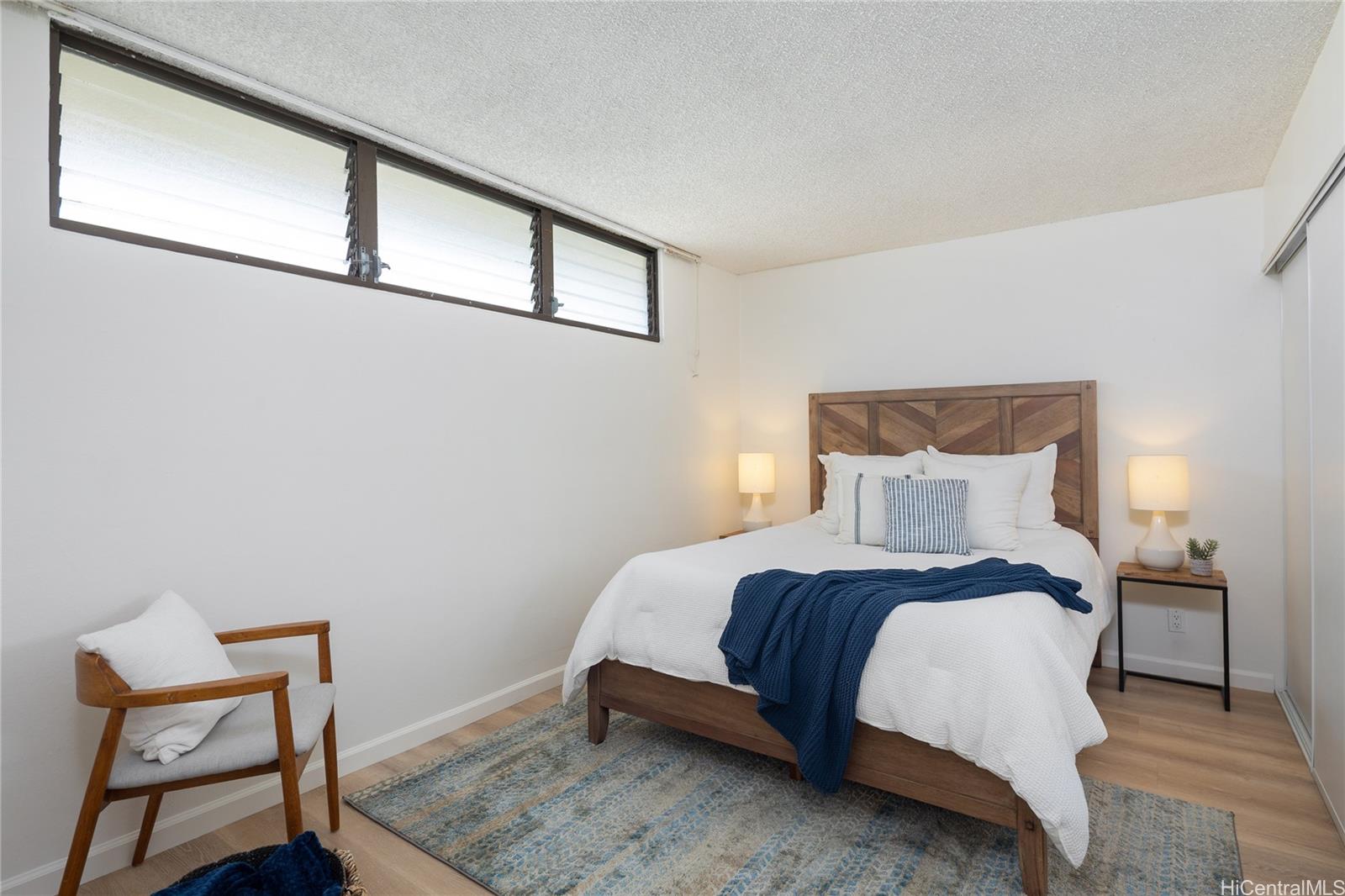 2092 Kūhiō Avenue, Unit 1003 Honolulu, HI 96815 - Photo 8 of 17 a bedroom with a bed and chair