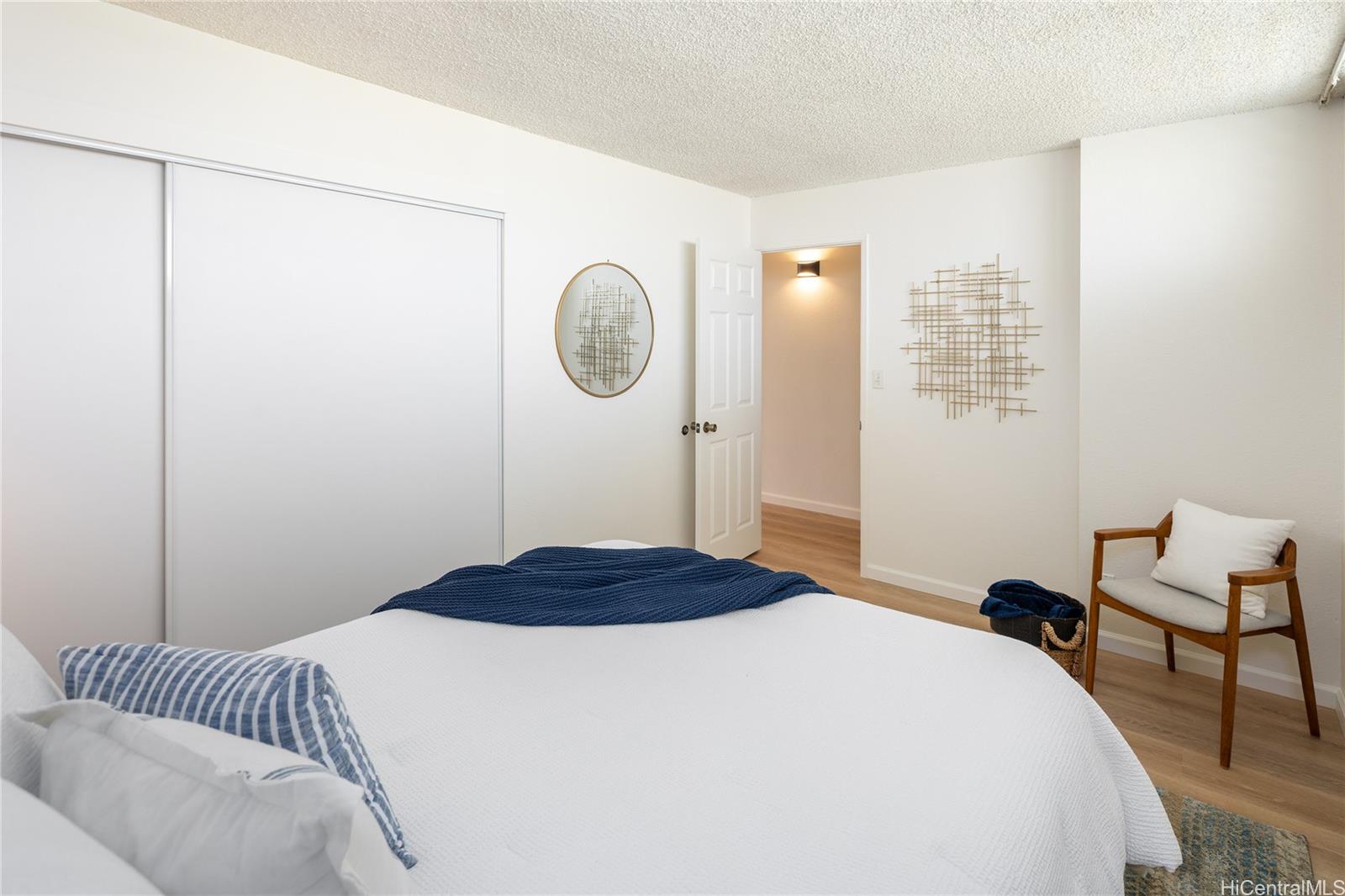 2092 Kūhiō Avenue, Unit 1003 Honolulu, HI 96815 - Photo 9 of 17 a bedroom with a bed and a chair