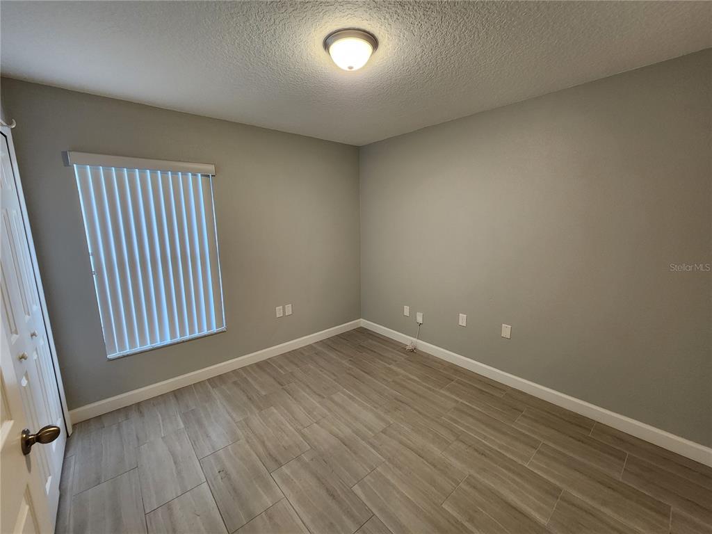 38 General Doolittle Road Daytona Beach, FL 32124 - Photo 11 of 19 an empty room with wooden floor and windows