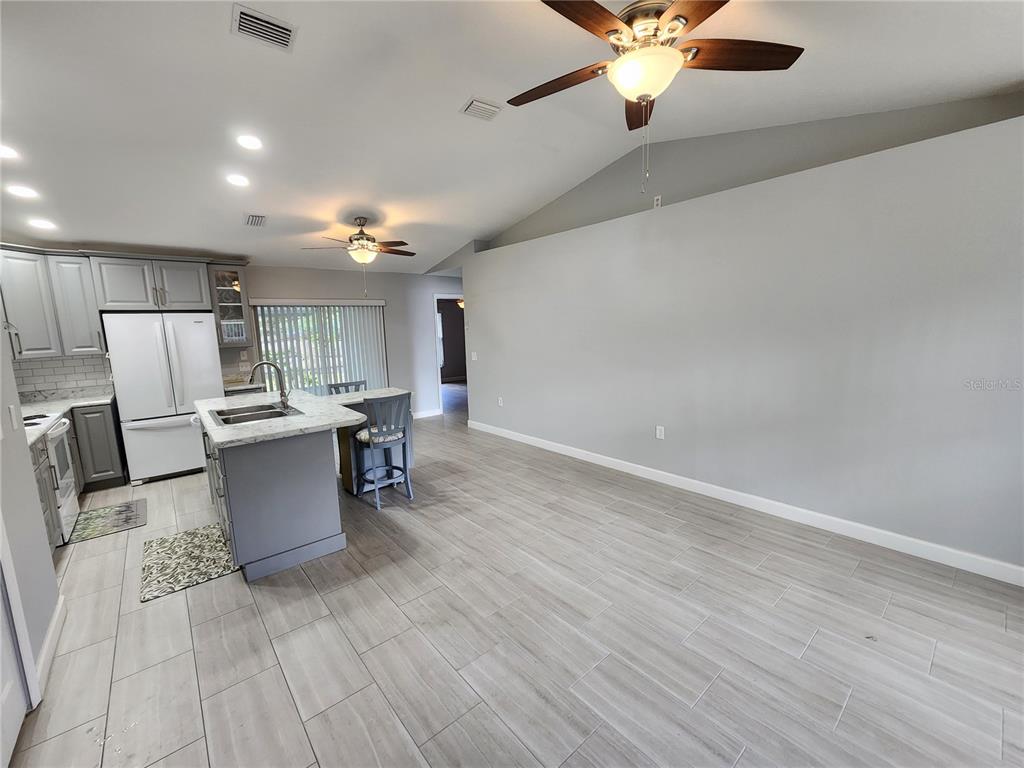 38 General Doolittle Road Daytona Beach, FL 32124 - Photo 15 of 19 a living room with couches and kitchen view with wooden floor