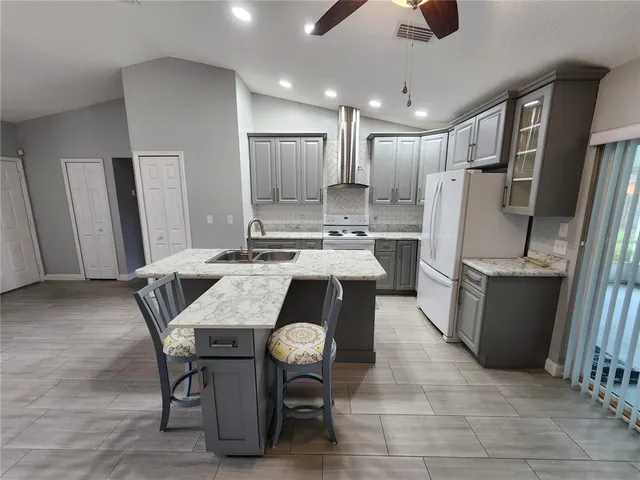 a kitchen with a table chairs refrigerator and wooden floor