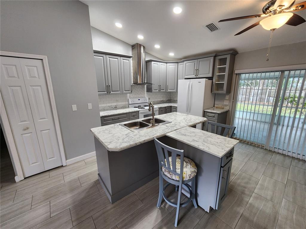 38 General Doolittle Road Daytona Beach, FL 32124 - Photo 18 of 19 a kitchen with a table chairs refrigerator and wooden floor