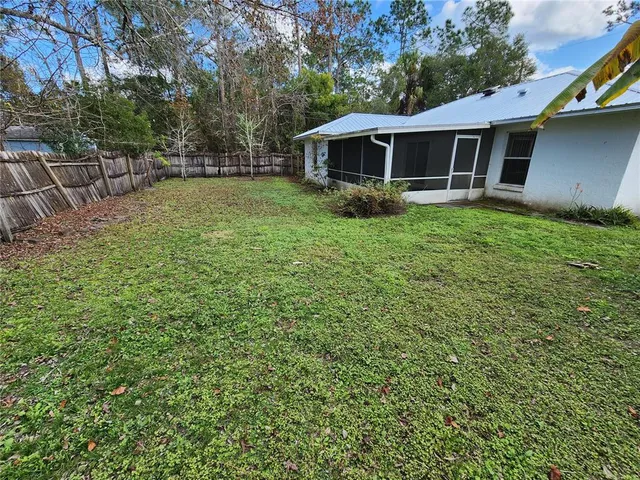 a view of a backyard with wooden fence