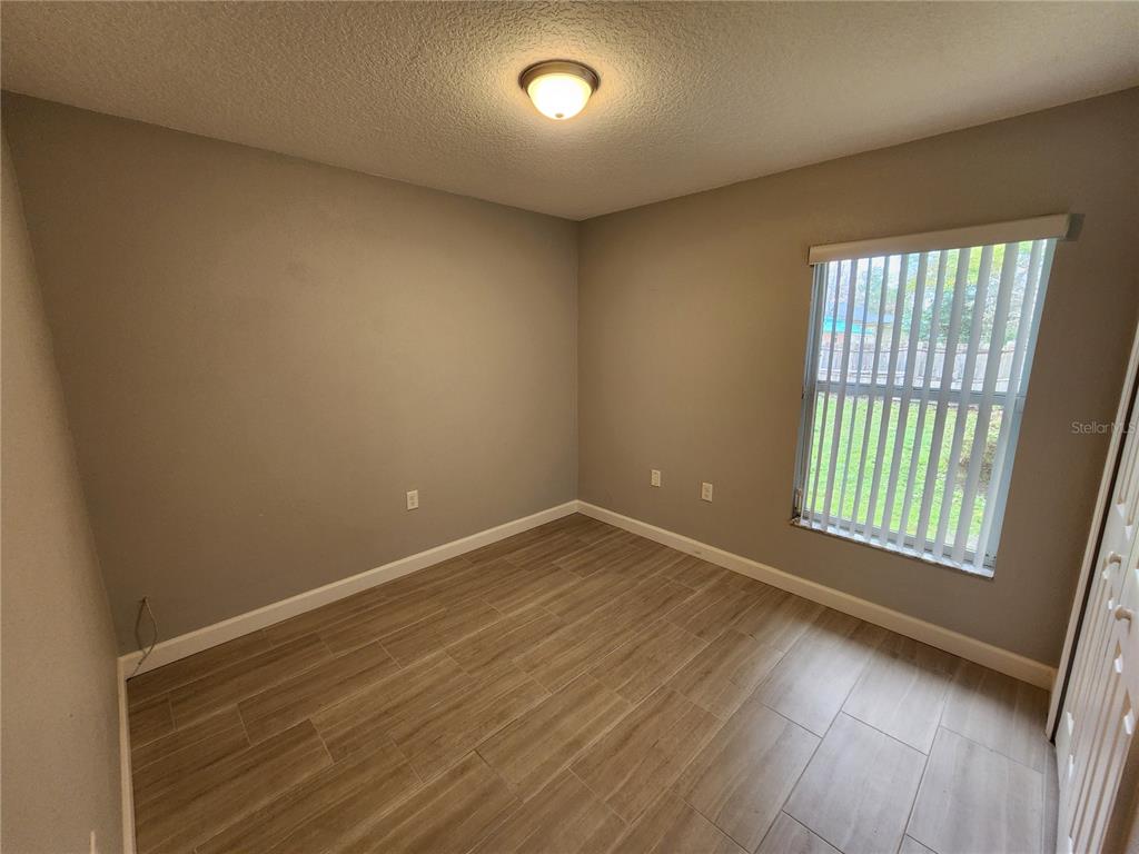 38 General Doolittle Road Daytona Beach, FL 32124 - Photo 10 of 19 an empty room with wooden floor and windows
