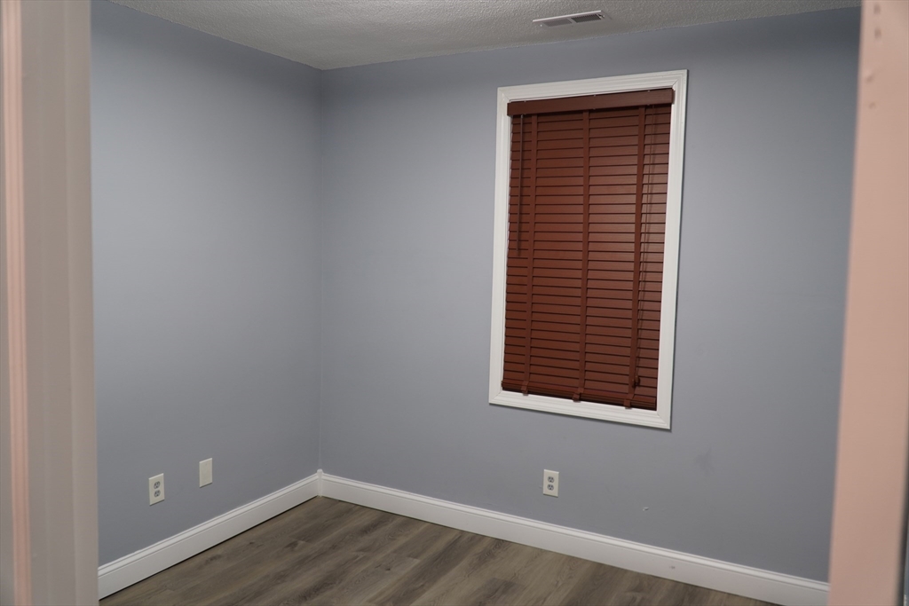 122 Norman Street West Springfield, MA 01089 - Photo 17 of 28 a view of an empty room with wooden floor and a window