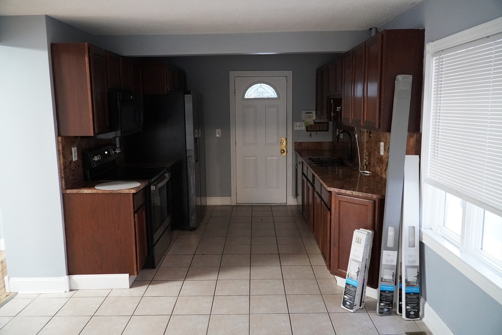 122 Norman Street West Springfield, MA 01089 - Photo 7 of 28 a kitchen with a refrigerator a stove top oven and cabinets