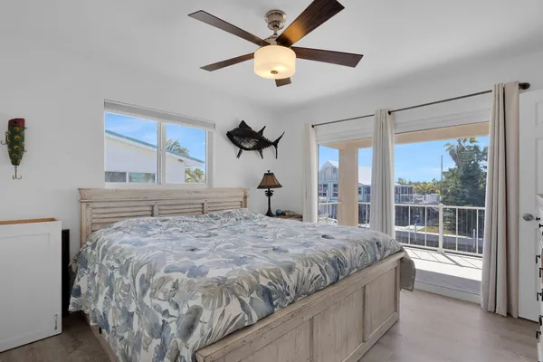 a bedroom with a large bed and a chandelier fan