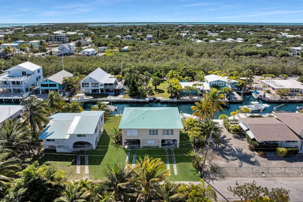 an aerial view of a house with a garden and lake view