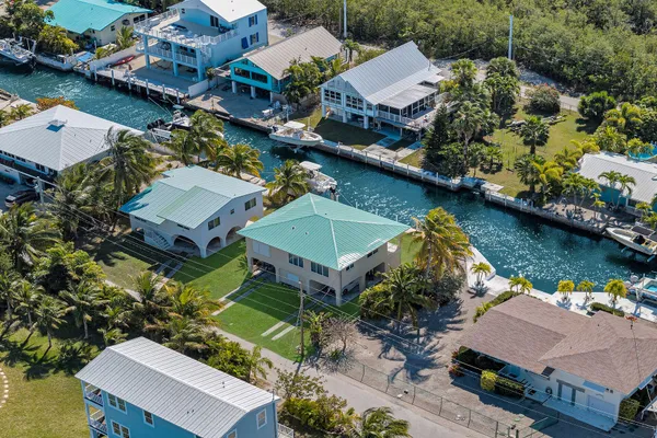 an aerial view of a house with a garden and lake view