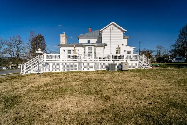 a view of a large house with a big yard and large trees