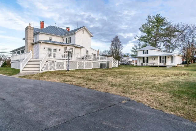 a view of a house with a big yard and large trees