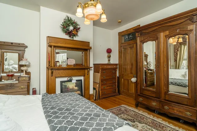 a bedroom with a bed and a mirror on dresser