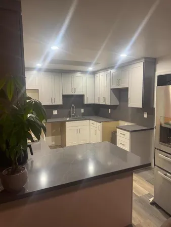 a kitchen with granite countertop a sink a stove and a refrigerator