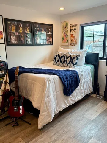 a bed sitting in a bedroom next to a window