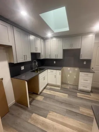 a kitchen with kitchen island granite countertop a sink cabinets and stainless steel appliances