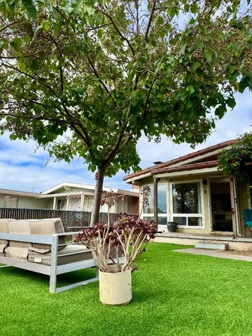 a view of a house with backyard porch and sitting area