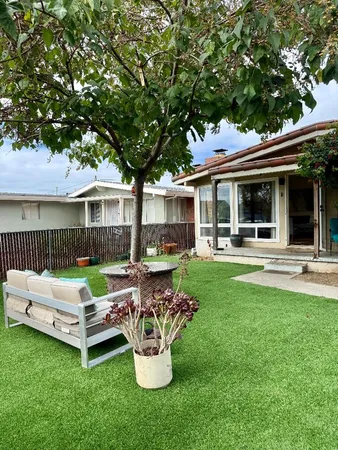a view of a house with backyard sitting area and garden