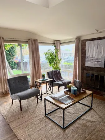 a living room with furniture a table and a large window