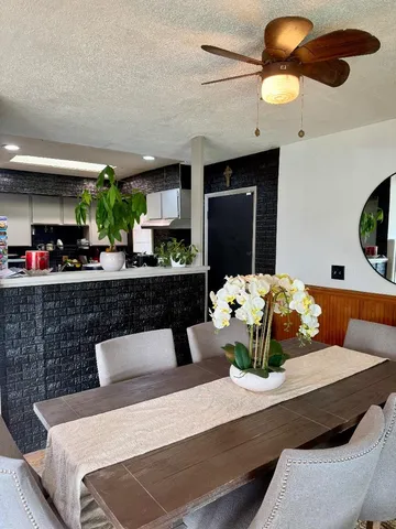 a living room with stainless steel appliances kitchen island granite countertop furniture and a fireplace