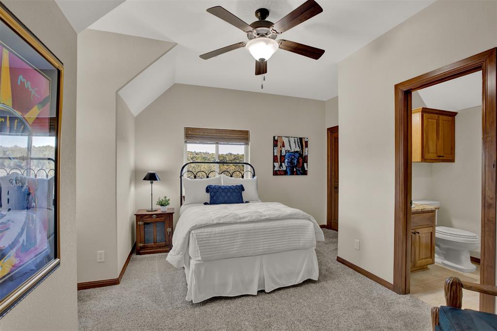 5300 Lookout Ridge Drive Marble Falls, TX 78654 - Photo 21 of 40 a bedroom with a bed and a chandelier