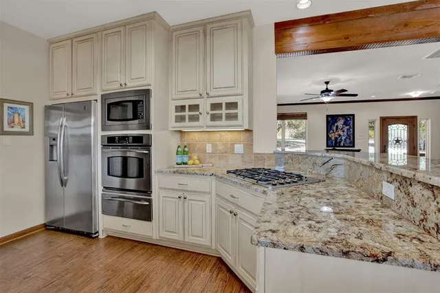 a kitchen with stainless steel appliances granite countertop a stove and a refrigerator