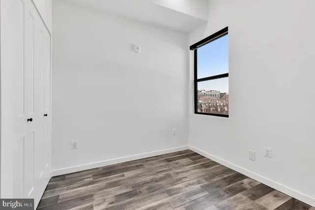a view of a small space with wooden floor and a window