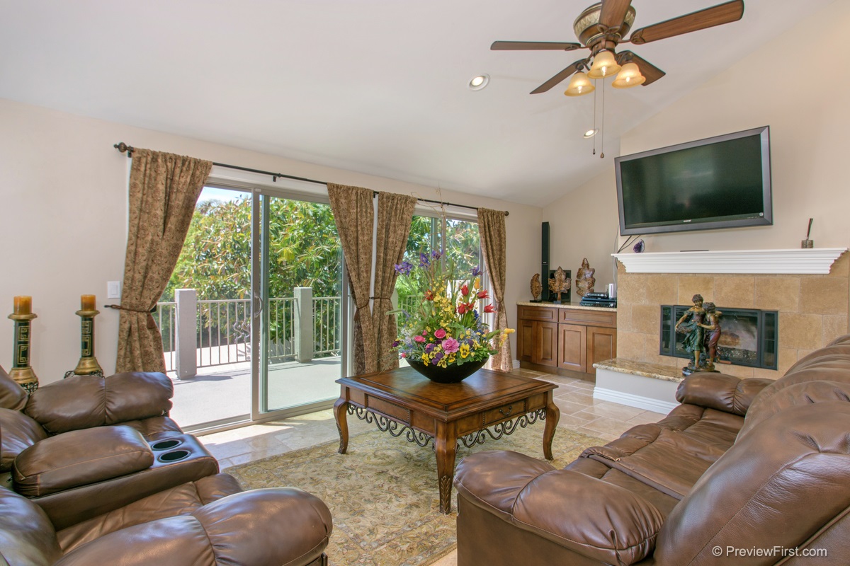 1748 Avocado Road Oceanside, CA 92054 - Photo 4 of 23 Large living room with fireplace, vaulted ceiling, ceiling fan, travertine floor, access to front balcony and front deck. Ocean Views!!