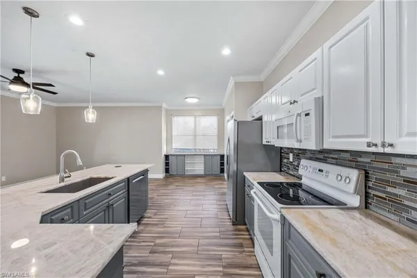 a kitchen with stainless steel appliances granite countertop a sink a stove and a wooden floors