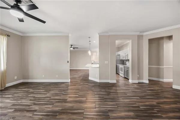 a view of an empty room with window and wooden floor