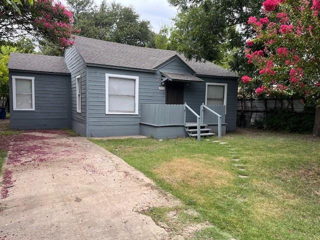 Bungalow-style home featuring roof with shingles and a front yard