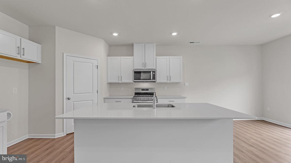 155 Littleworth Road Manahawkin, NJ 08050 - Photo 7 of 32 a kitchen with stainless steel appliances a sink a stove a microwave and cabinets