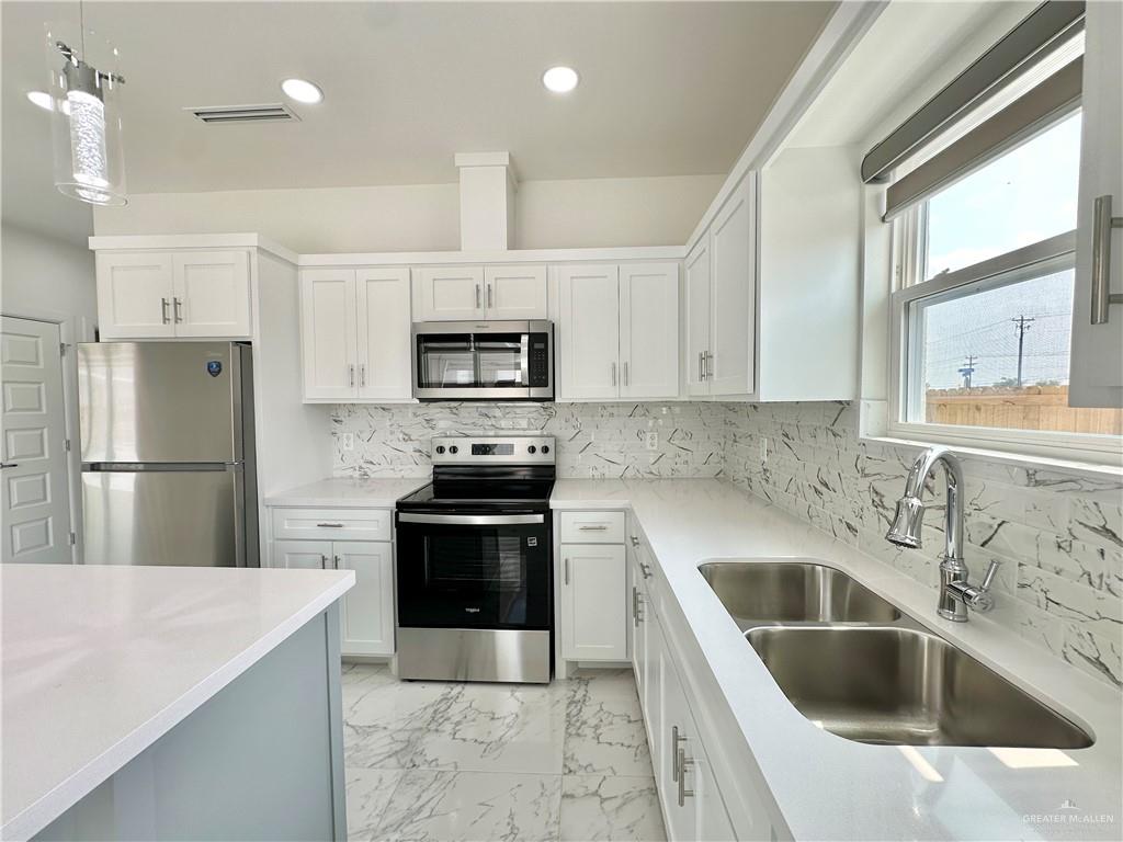 2404 East Viviana Street, Unit 1 Edinburg, TX 78542 - Photo 4 of 14 a kitchen with a sink stove and refrigerator