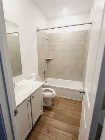 a bathroom with a granite countertop sink a toilet and shower