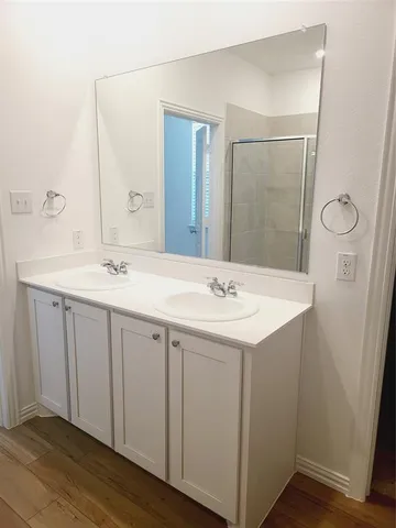 a bathroom with a double vanity sink and mirror