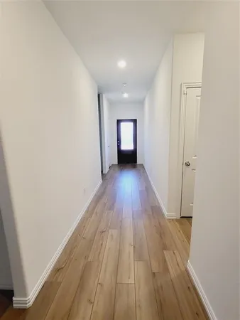 a view of a room with wooden floor and a window
