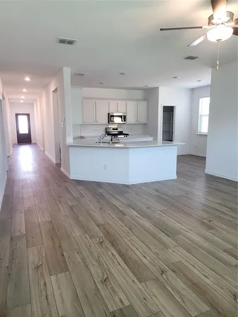 a view of a large kitchen with wooden floor and a large window