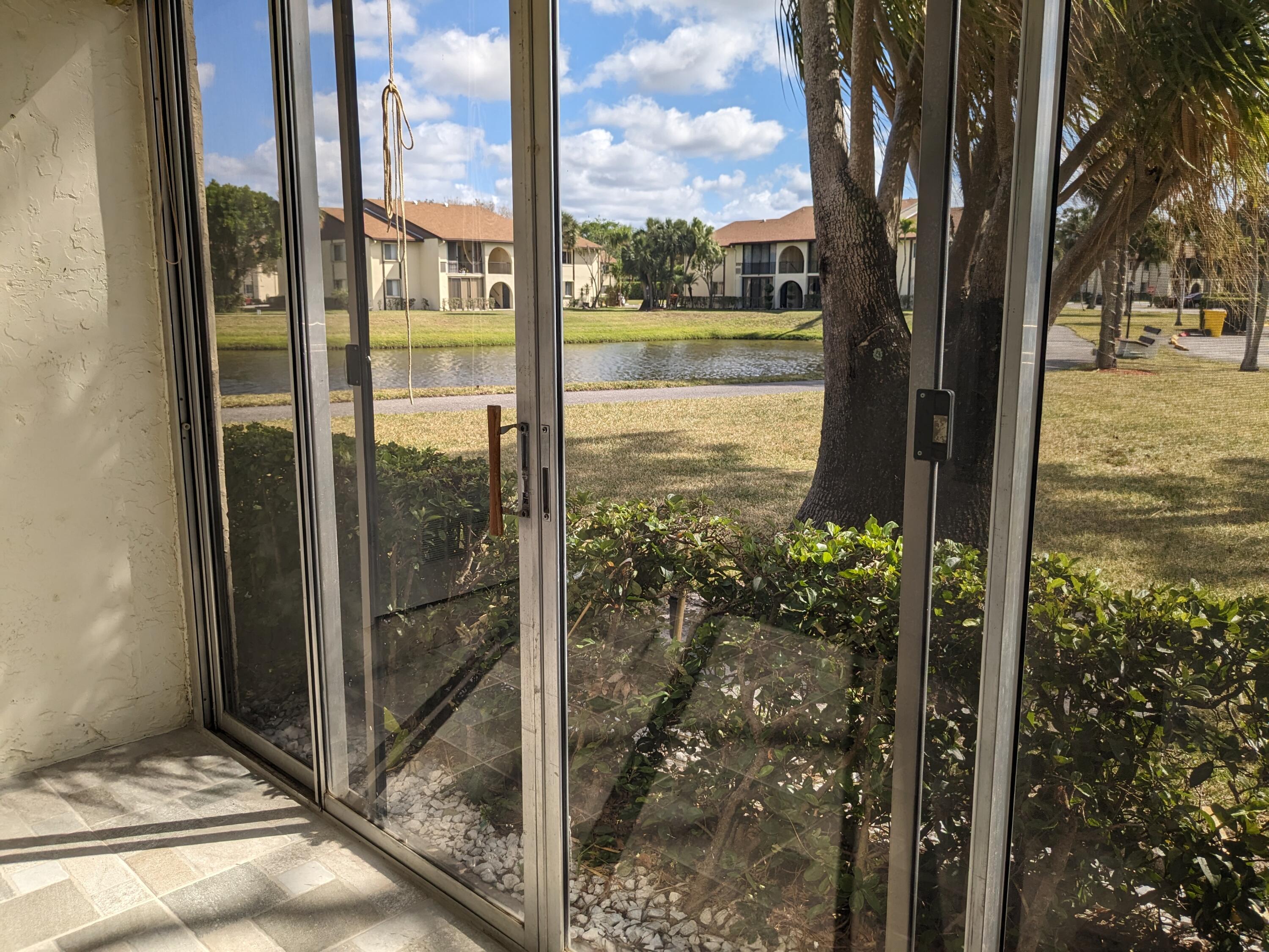 a view of a glass door and a yard from a balcony