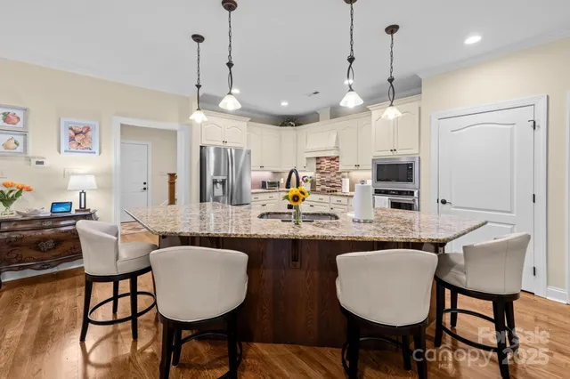 a kitchen with kitchen island granite countertop a table and chairs in it