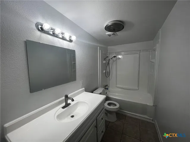 a bathroom with a sink a toilet a mirror and shower