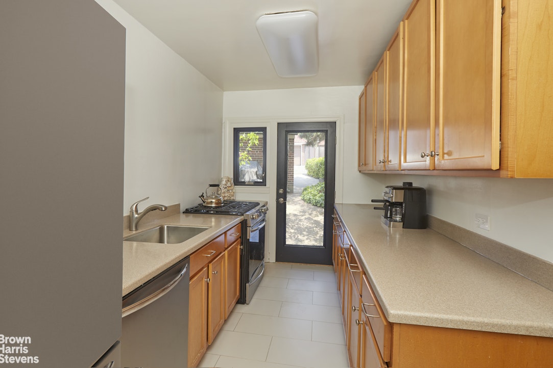 34-27 87th Street Queens, NY 11372 - Photo 6 of 19 a kitchen with a sink a stove and cabinets